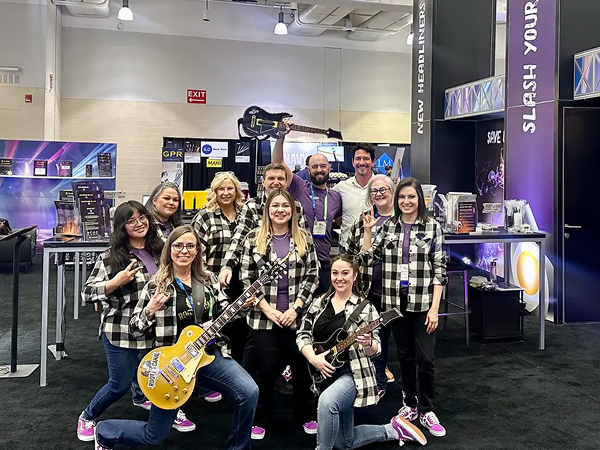 A group at the conference posing together with guitars.